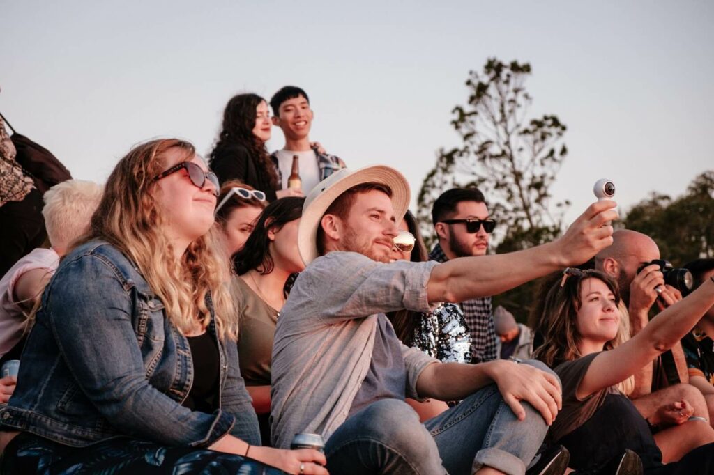 People watching an event sat down on a hill